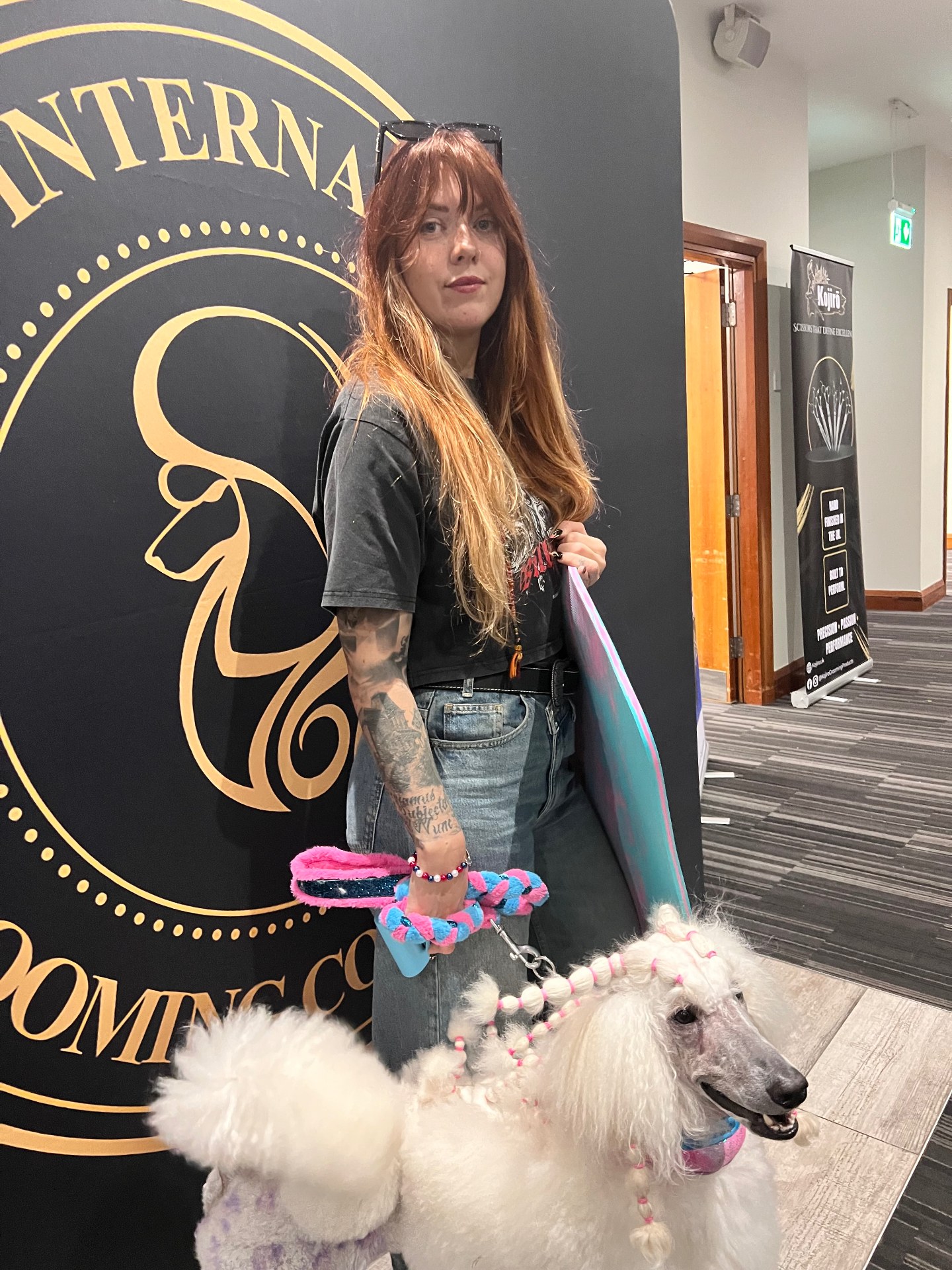 Groomer with a beautifully groomed white poodle